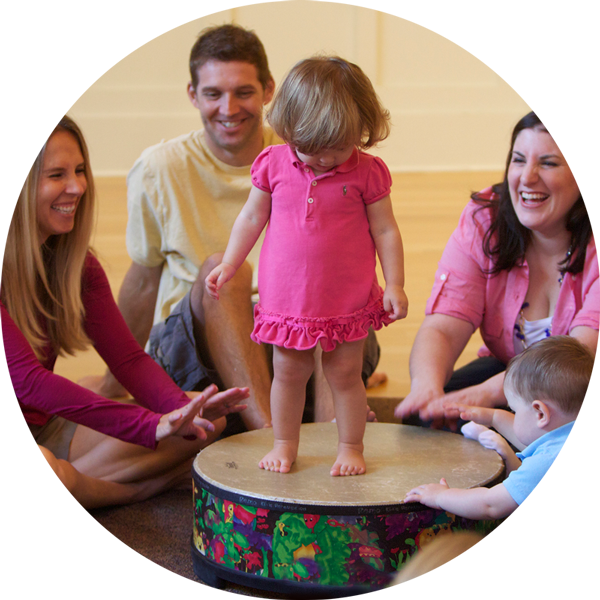 Little girl standing on drum in a Music Together class