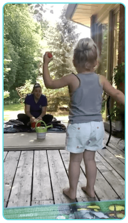Granddaughter on porch dancing with egg shakers and teacher at other end drumming