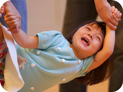 Little girl swinging from her mommy's hands in a Music Together class