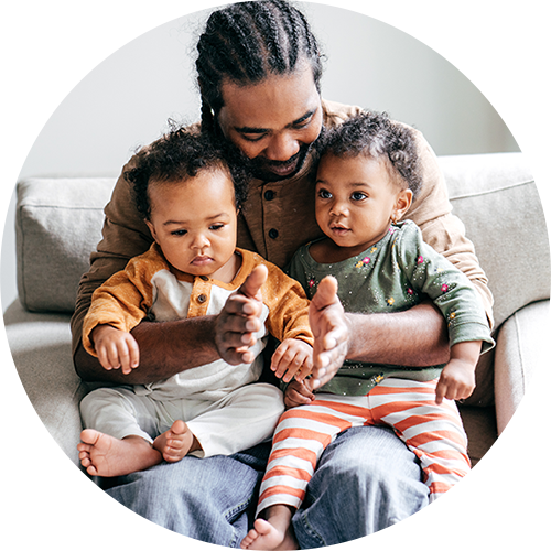 father and children sitting in a chair